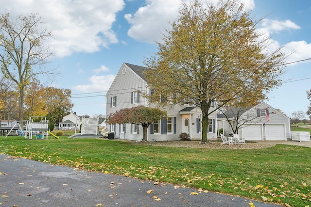 view of front facade featuring a playground, a front yard, and a garage