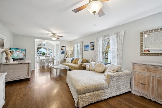 living room featuring dark hardwood / wood-style flooring, ceiling fan, and plenty of natural light