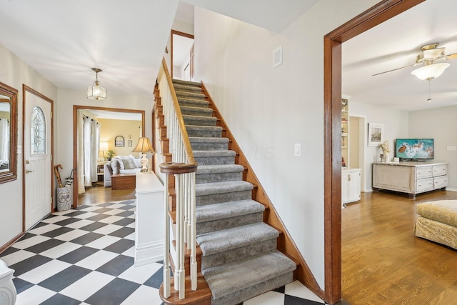 foyer entrance with dark hardwood / wood-style flooring and ceiling fan with notable chandelier