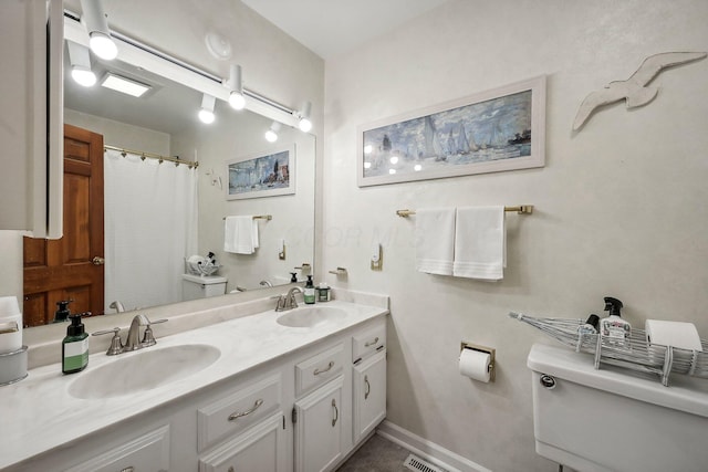 bathroom with walk in shower, vanity, and toilet