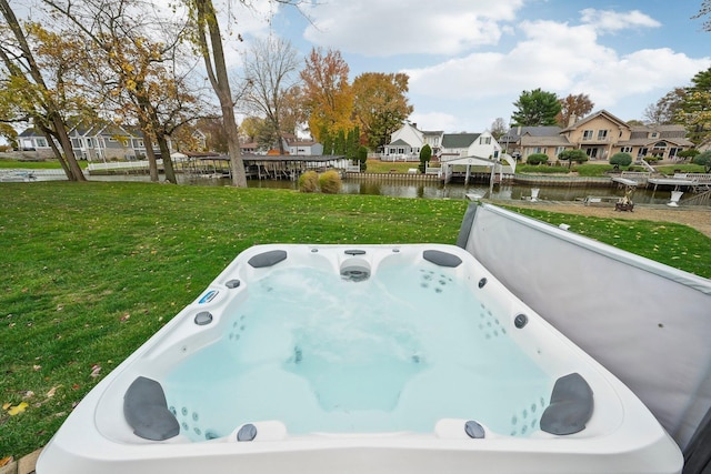 exterior space with a water view and a hot tub