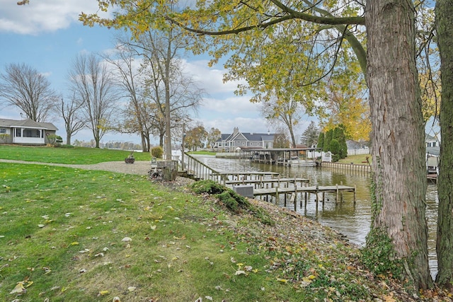 dock area featuring a lawn and a water view