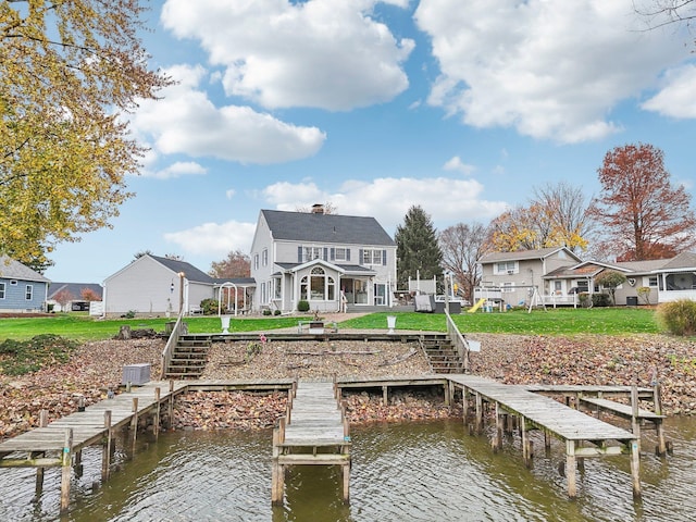 view of dock featuring a lawn and a water view