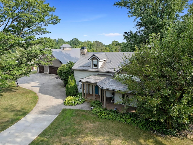 view of front of house featuring a porch, a garage, an outdoor structure, and a front lawn