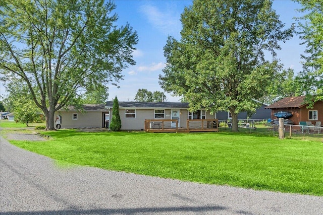 single story home with a front yard and a deck