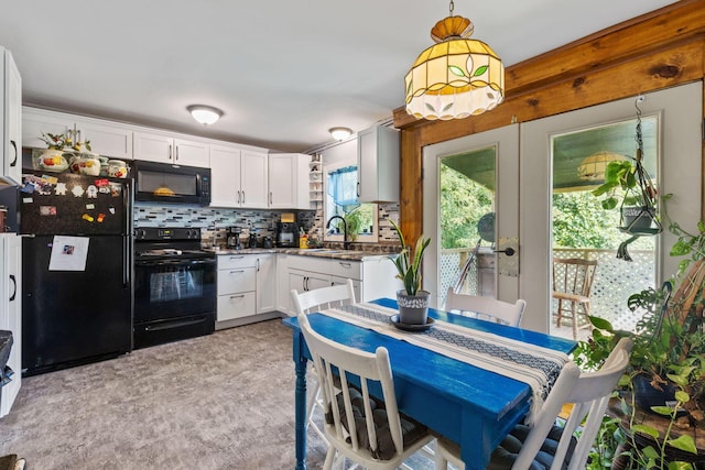 kitchen with light carpet, black appliances, decorative backsplash, decorative light fixtures, and white cabinetry