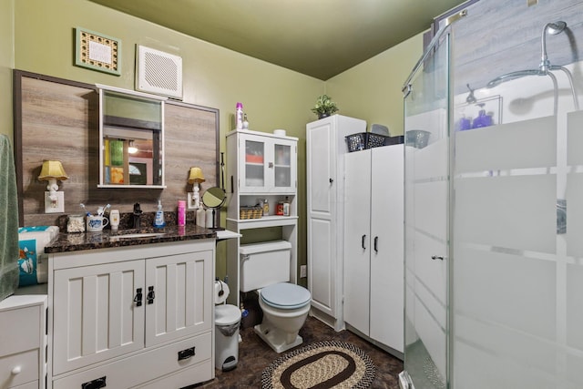 bathroom with vanity, toilet, and a shower with door