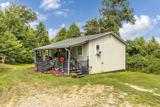 view of outdoor structure with a yard, cooling unit, and covered porch