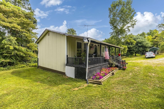 view of home's exterior with a lawn and a porch