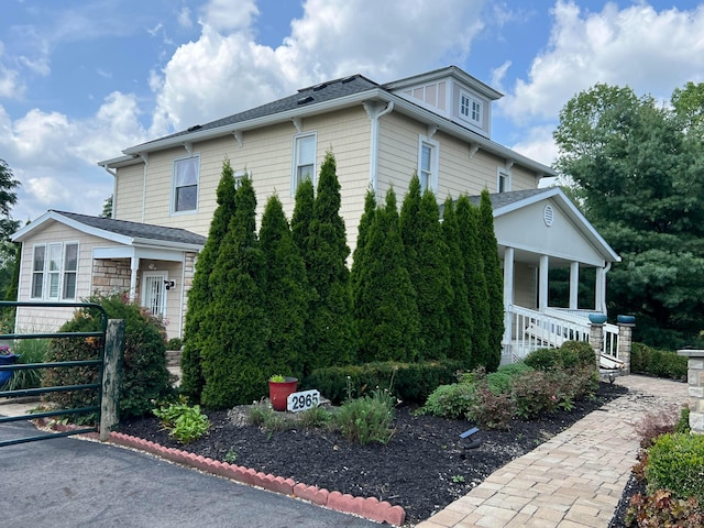 view of side of home featuring covered porch