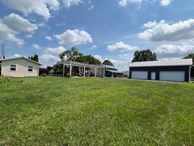 view of yard with an outbuilding, a pergola, and a garage