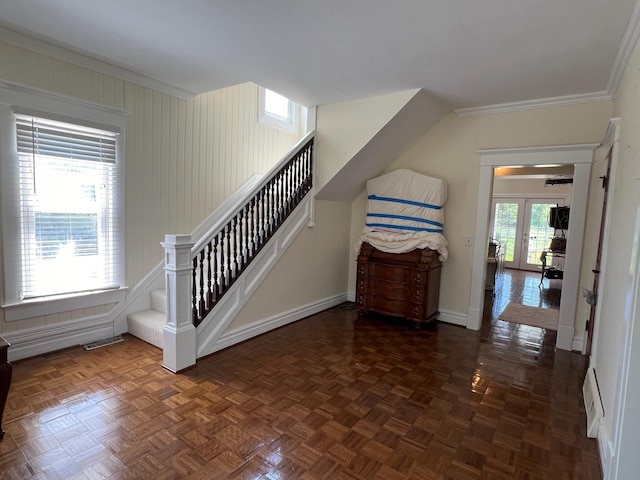 stairway with plenty of natural light, ornamental molding, parquet floors, and french doors