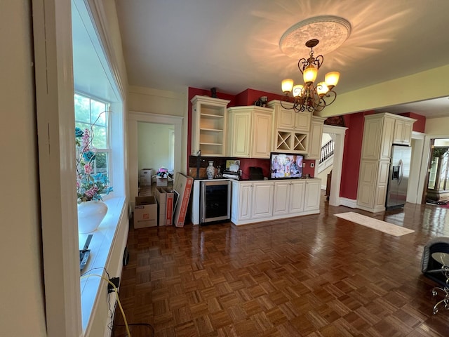 kitchen featuring dark parquet flooring, hanging light fixtures, stainless steel refrigerator with ice dispenser, a notable chandelier, and beverage cooler