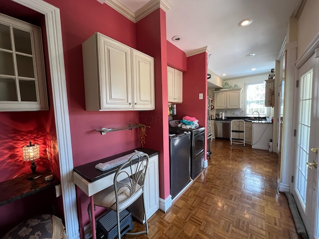 kitchen with range with electric cooktop, sink, washing machine and dryer, stainless steel dishwasher, and ornamental molding