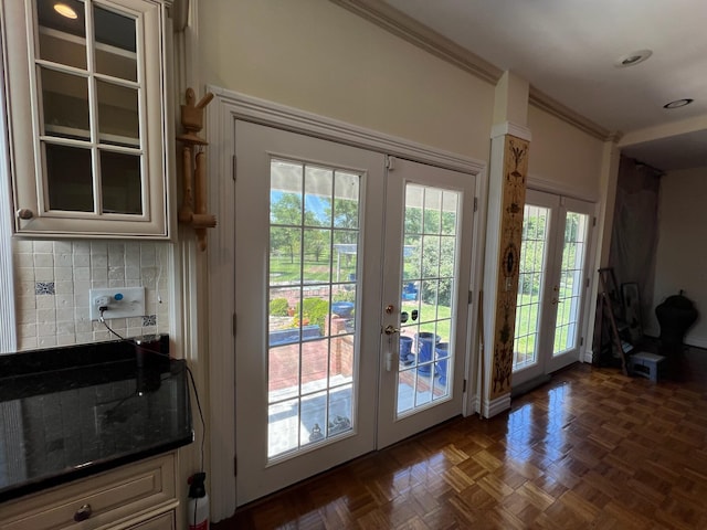 doorway with french doors, dark parquet flooring, and crown molding