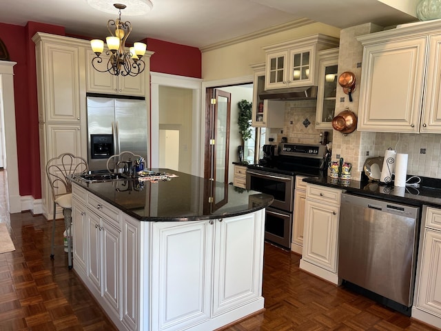 kitchen with a center island, appliances with stainless steel finishes, tasteful backsplash, decorative light fixtures, and a chandelier