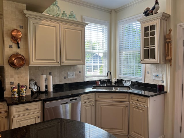 kitchen featuring dark stone countertops, a wealth of natural light, dishwasher, and sink