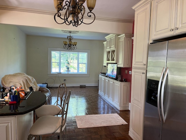 kitchen featuring stainless steel fridge with ice dispenser, crown molding, cream cabinets, a chandelier, and decorative light fixtures