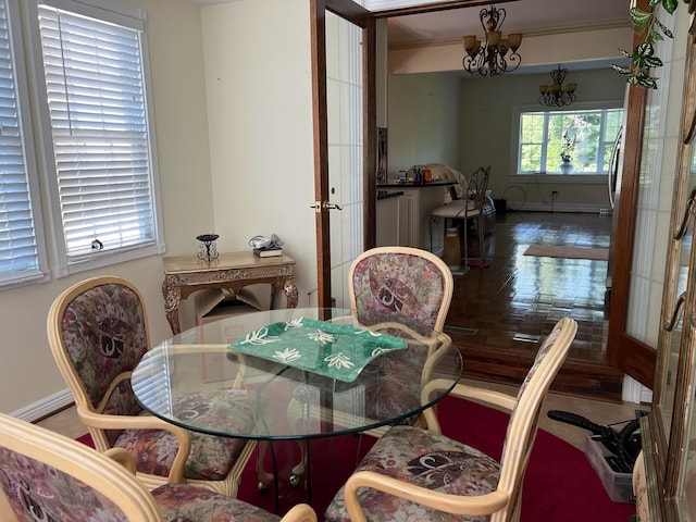 dining area featuring hardwood / wood-style floors, french doors, ornamental molding, and a notable chandelier