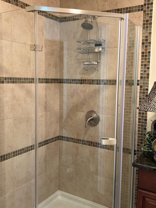 bathroom with vanity and a shower with door