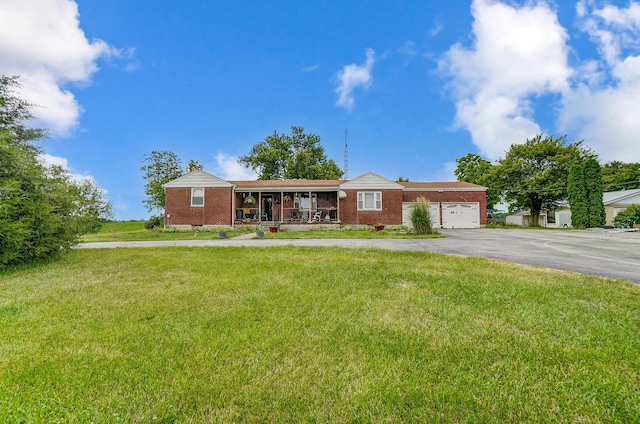 single story home featuring a garage, covered porch, and a front lawn