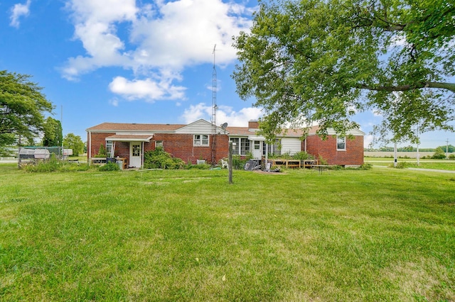 rear view of house featuring a lawn