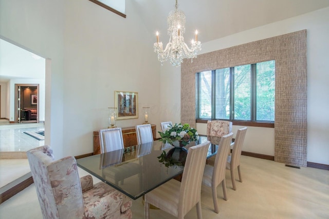 carpeted dining space featuring a towering ceiling and an inviting chandelier