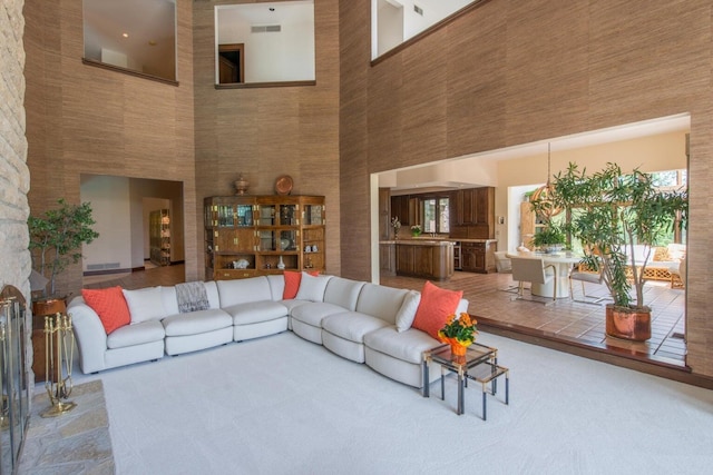 carpeted living room with a towering ceiling