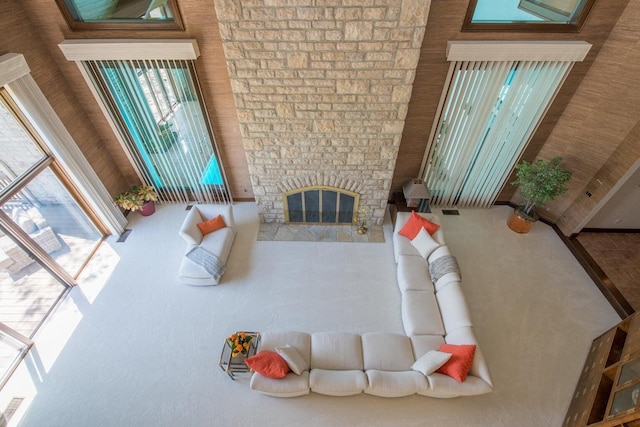 living room featuring a stone fireplace and a high ceiling