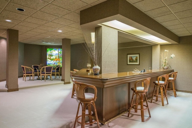 bar featuring a paneled ceiling and carpet floors