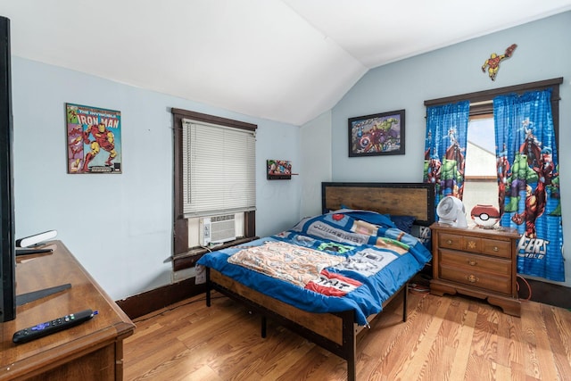 bedroom featuring cooling unit, lofted ceiling, and light hardwood / wood-style flooring