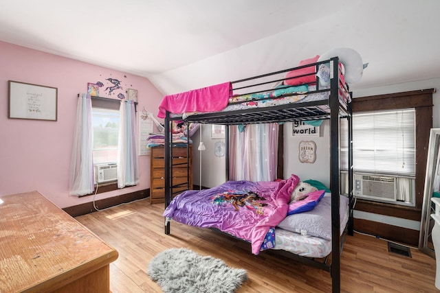 bedroom featuring hardwood / wood-style flooring, cooling unit, and lofted ceiling