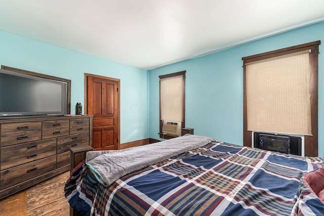 bedroom with cooling unit and wood-type flooring