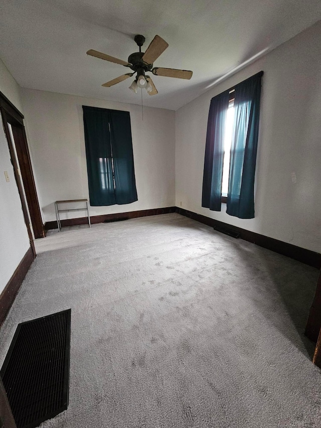 empty room featuring carpet flooring and ceiling fan