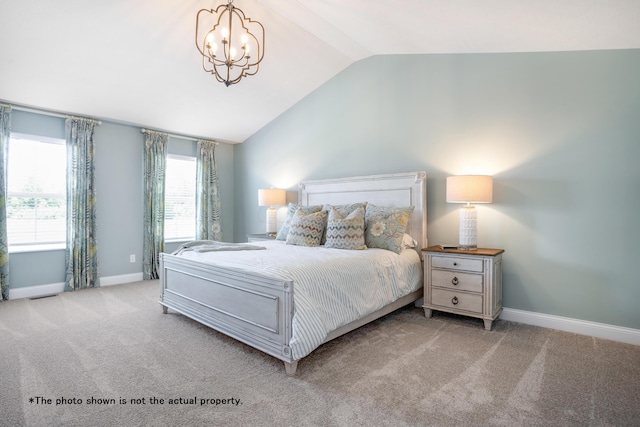 bedroom with a chandelier, light colored carpet, and lofted ceiling