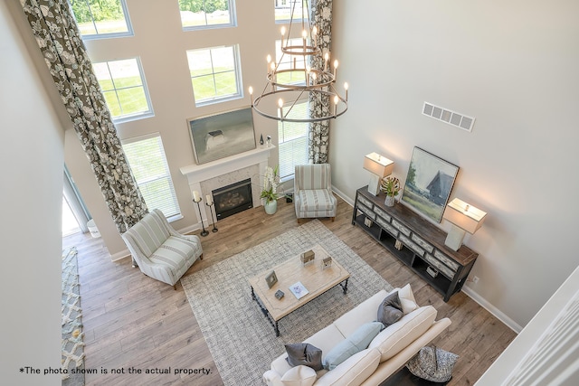 living room featuring a chandelier, a high ceiling, and light hardwood / wood-style flooring