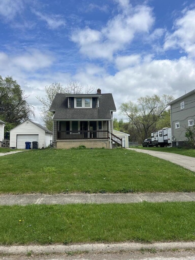 view of front facade with a front yard, an outbuilding, a porch, and a garage