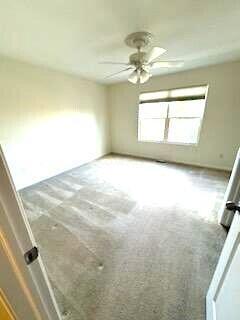 empty room featuring ceiling fan and carpet floors