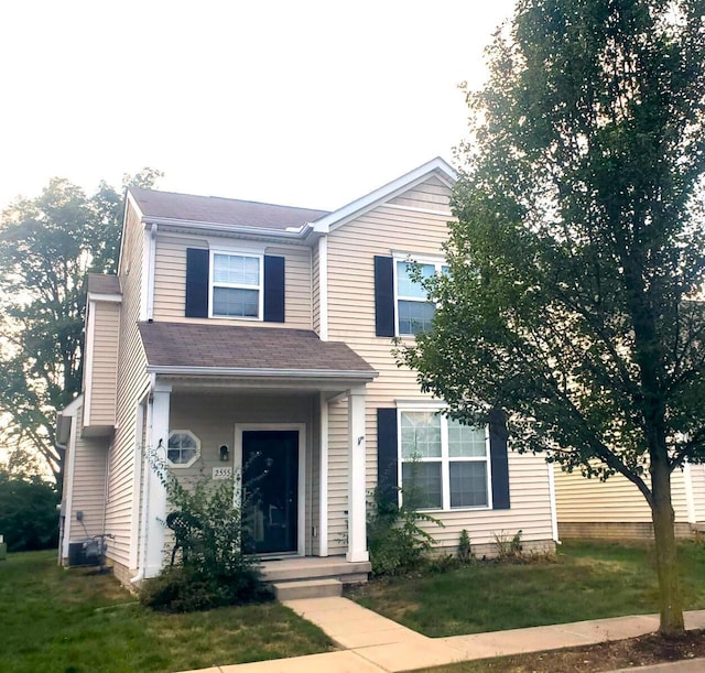 view of front of house with a front lawn and central air condition unit