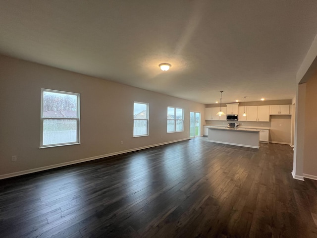 unfurnished living room with dark hardwood / wood-style flooring