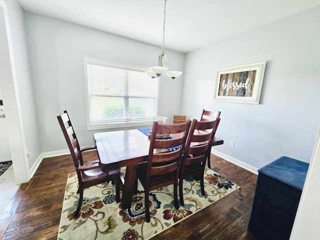 dining area with dark wood-type flooring and a chandelier