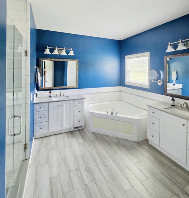 bathroom featuring vanity, hardwood / wood-style floors, and plus walk in shower