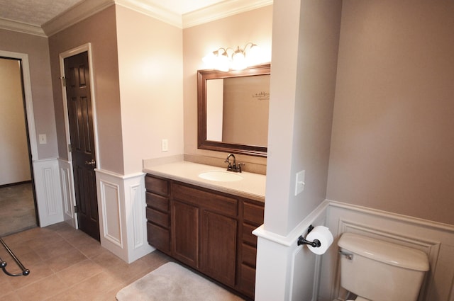 bathroom featuring toilet, tile patterned flooring, crown molding, and vanity