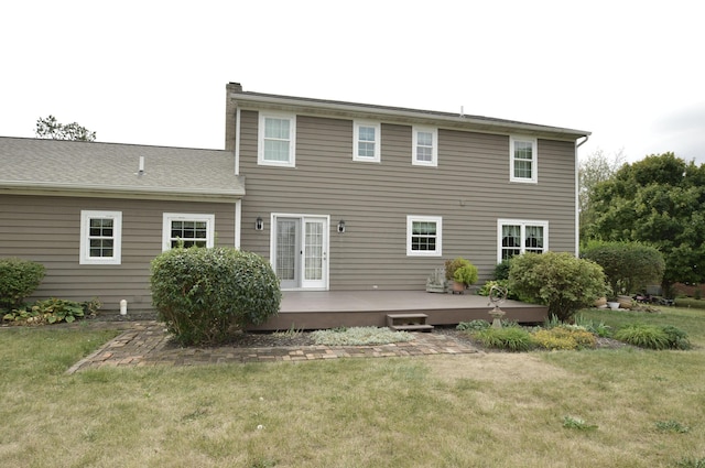 back of property with a deck and a lawn