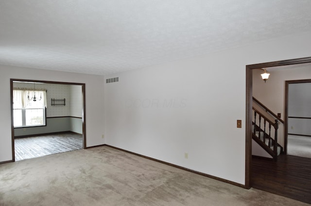 carpeted spare room with a textured ceiling