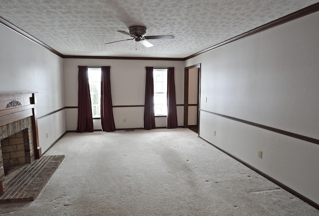 unfurnished living room featuring a textured ceiling, a brick fireplace, crown molding, ceiling fan, and light carpet