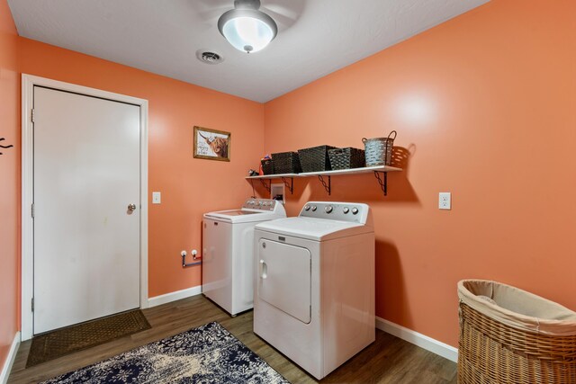 washroom with light wood-type flooring, laundry area, visible vents, and washing machine and clothes dryer