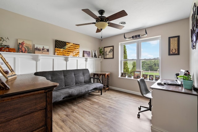 office space featuring light wood finished floors, baseboards, visible vents, and a ceiling fan