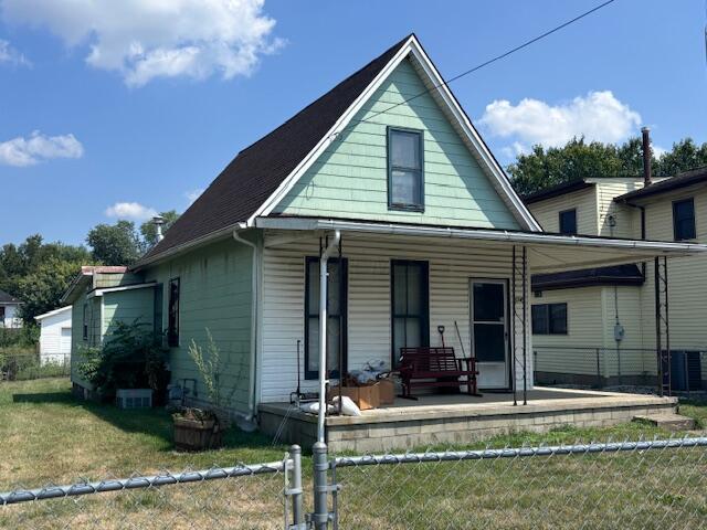 bungalow-style house with central AC, a front lawn, and a porch