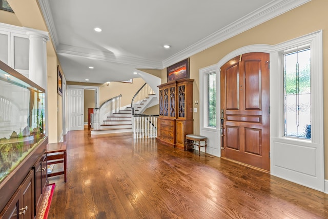 entryway with hardwood / wood-style floors, ornate columns, and crown molding